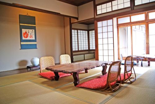 comedor con mesa de madera y sillas en Dougoya en Matsuyama