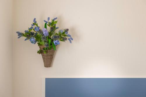 a vase of blue flowers on a white table at Apartamentos Herri Ondo REFUGIO CLIMATICO in Iturmendi