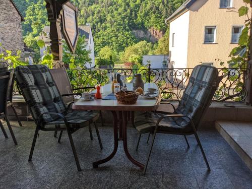 un tavolo e 4 sedie su un balcone con tavolo e sedie di Weingut Pension Hammes-Krüger a Ellenz-Poltersdorf