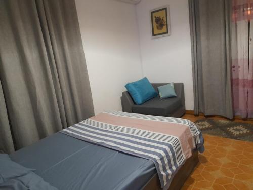 1 dormitorio pequeño con 1 cama y 1 silla en Residence Le Choisy, en Grand Baie