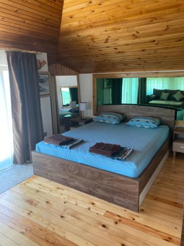 a large bed in a room with a wooden ceiling at Villas Sozopol in Sozopol