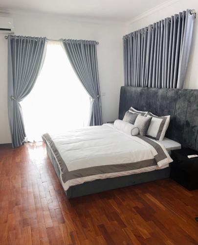 a bedroom with a bed and a large window at The Zen Loft - 2BR Open Plan Apt W/Pool+Smart Lock in Lekki