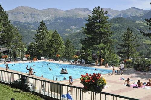 people in a swimming pool with mountains in the background at 1.2.3 SOLEIL in Barcelonnette