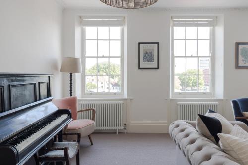 a living room with a piano and chairs and windows at Redcliffe Parade No 9 I City Centre in Bristol
