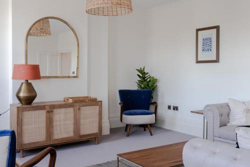 a living room with a blue chair and a mirror at Redcliffe Parade No 9 I City Centre in Bristol
