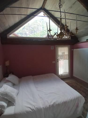 ein Schlafzimmer mit einem großen Bett und einem großen Fenster in der Unterkunft Casa Vacanza La Baitina in Antronapiana