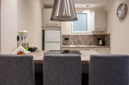 a kitchen with a counter with two chairs and a sink at CENTRAL ROOF NK CHANIA in Chania