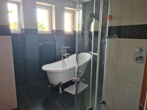 a bathroom with a tub and a glass shower at Airport Rooms in Prague