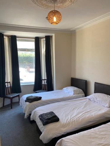 um quarto de hotel com três camas e uma janela em Aegir House em Gainsborough