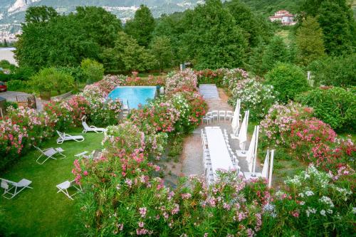un jardin fleuri et une piscine dans l'établissement Amata Valgre Affittacamere, comfort e pulizia eccezionali!!, à Olginate