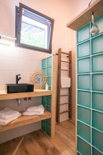 a bathroom with green and white tiles and a sink at Welcôm Apparts-chic et intimiste-100m du Port in La Teste-de-Buch