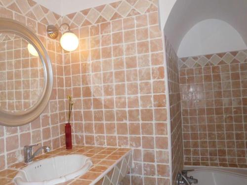 une salle de bain avec un lavabo, un miroir et une baignoire dans l'établissement Les cigales, à Hyères