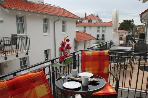 a balcony with a table and chairs on a balcony at Haus Meeresblick - Ferienwohnung Sandkorn A 2.07 (Ref. 128695) in Baabe