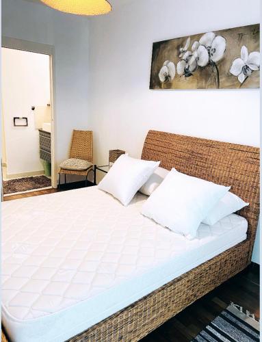 - une chambre avec un grand lit blanc et des oreillers blancs dans l'établissement Perle Rare , sur La Rochelle Appartement avec parking, à La Rochelle