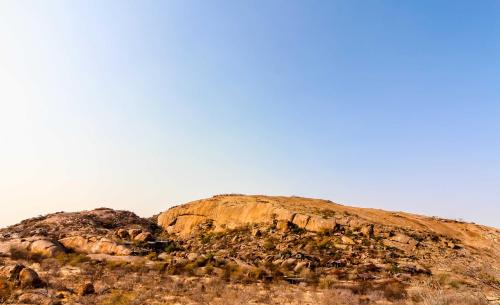 a rocky mountain with a blue sky in the background at Ondudu Safari Lodge in Omaruru