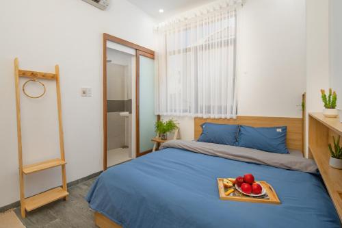 a bedroom with a bed with a tray of fruit on it at ChiPa Homestay in Da Nang