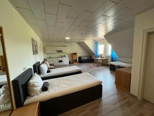 a large room with two beds and a kitchen at Hotel Rehkitz in Halle Westfalen