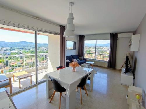 un salon avec une table et des chaises blanches dans l'établissement T3 75m² Incroyable Vue Mer/Piscine/Tennis/Terrasse, à Antibes