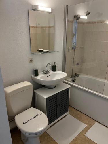 Un baño con inodoro, lavabo y bañera. en Une parenthèse à dives sur mer, en Dives-sur-Mer