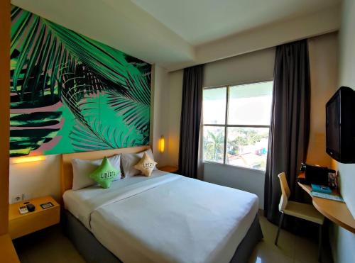 a hotel room with a bed and a window at Liberta Hotel Kemang in Jakarta