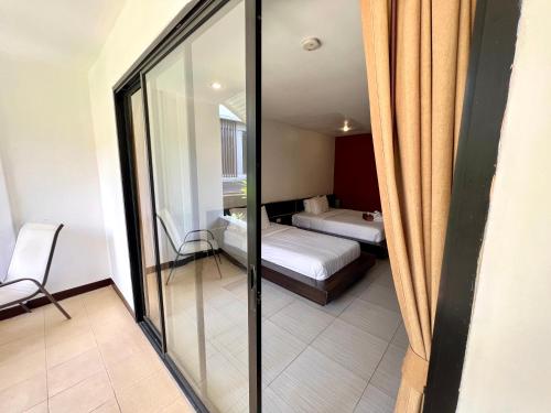 a view of a bedroom with a bed and a mirror at Hotel La Villa Khon Kaen in Khon Kaen