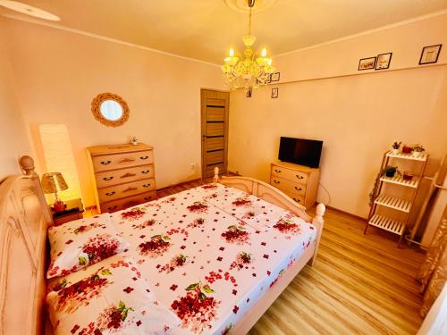 a bedroom with a bed with flowers on it at By The Sea for Family in Mangalia