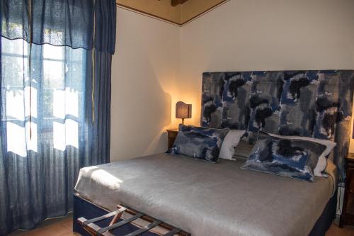 a bedroom with a large bed with blue curtains at Residenza Ca De Frati in Arezzo