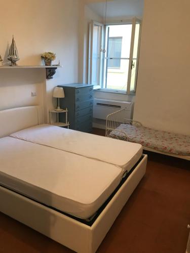 um quarto com uma cama, uma cómoda e uma janela em Il gioiello di Orbetello em Orbetello