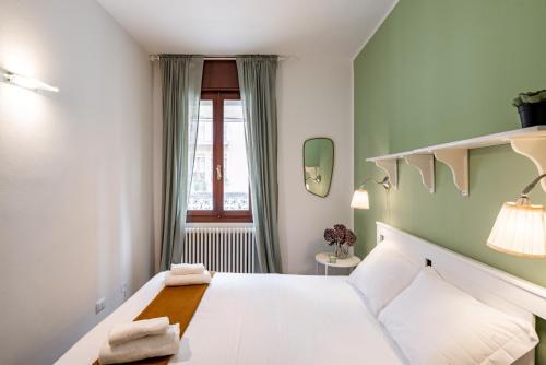 um quarto com uma cama branca e uma janela em Padova Santa Croce Apartment em Pádua