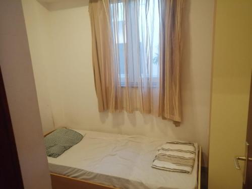 - un petit lit dans une chambre avec fenêtre dans l'établissement Anita, à Zadar