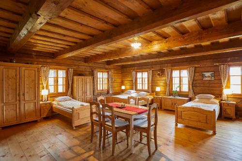 ein Zimmer mit einem Tisch und Stühlen in einer Hütte in der Unterkunft Volarská roubenka in Volary