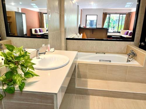 a bathroom with a sink and a bath tub at Hotel La Villa Khon Kaen in Khon Kaen