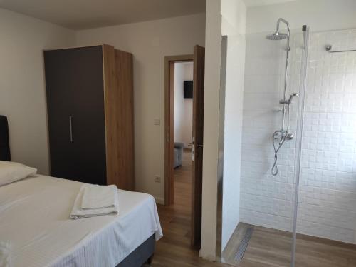 La salle de bains est pourvue d'une douche et d'un lit. dans l'établissement Joy I, à Šibenik