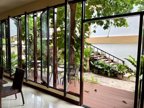 a balcony with glass doors and chairs and plants at Hotel La Villa Khon Kaen in Khon Kaen