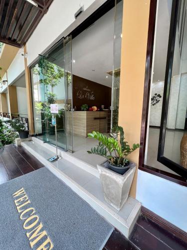 a store front with a potted plant in the window at Hotel La Villa Khon Kaen in Khon Kaen