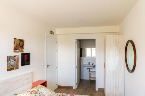a bedroom with a bed and a bathroom with a sink at Apartamentos Herri Ondo REFUGIO CLIMATICO in Iturmendi