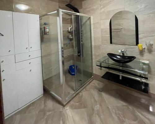 Un baño con ducha de cristal y lavabo. en Луксозен апартамент в сърцето на Сандански, en Sandanski