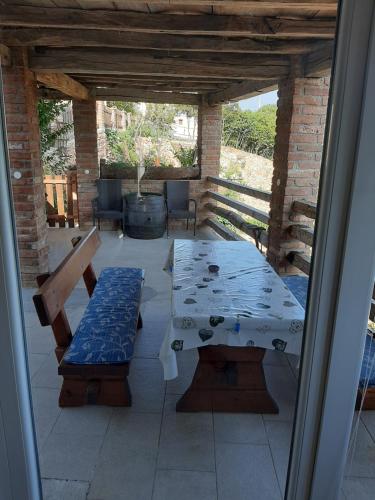 un patio con una mesa y bancos en un porche en Jelica, en Polje