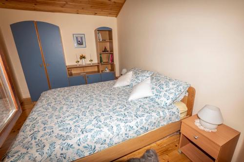 Schlafzimmer mit einem Bett mit einer blauen und weißen Bettdecke in der Unterkunft Holiday Home Mare near River in Karlovac