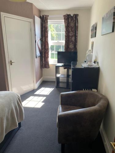 a bedroom with a bed and a chair and a desk at The Chase Inn in Bishops Frome