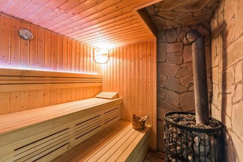 a wooden sauna with a stone wall at Osada Ostoja in Radziejowa