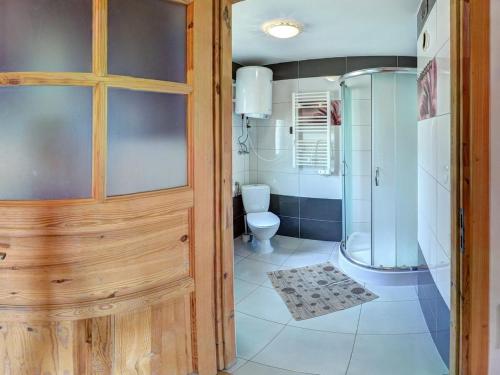 a bathroom with a shower and a toilet and a door at Osada Ostoja in Radziejowa