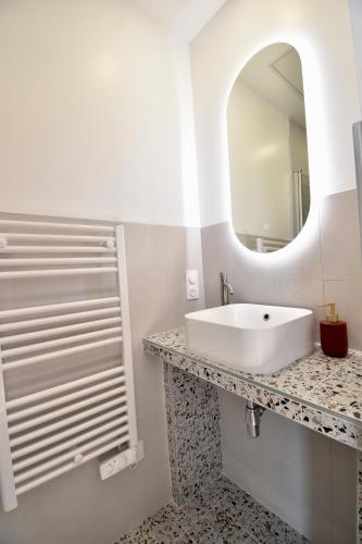 une salle de bain blanche avec un lavabo et un miroir dans l'établissement ❊ Terracotta ❊ Centre ville, vue jardin, à Pontivy