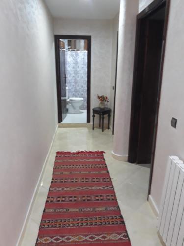 a hallway with a toilet and a red rug at The Orchard Comfy & Cozy Apartment 2 in Ifrane