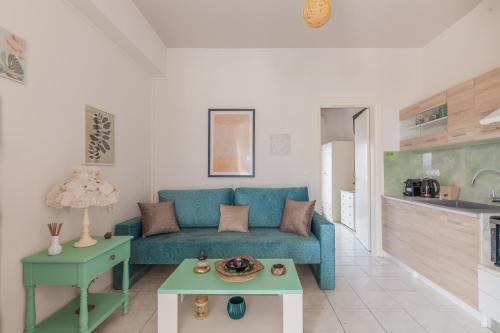 a living room with a blue couch and a table at Kissamos sea view beach apartments in Kissamos