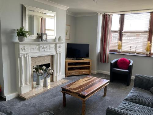a living room with a fireplace and a tv at Seafront, Cleethorpes apt’s in Cleethorpes