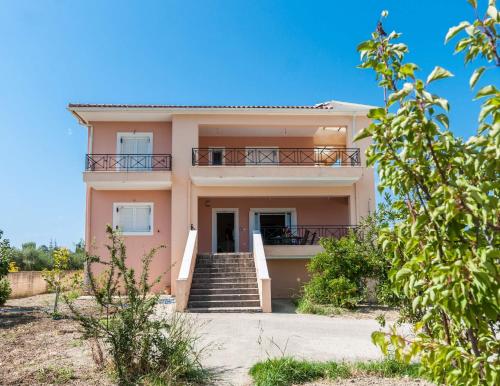 a large pink house with stairs and a balcony at Casa Armonia Zakynthos: 2-Floor Residence in Gaïtánion