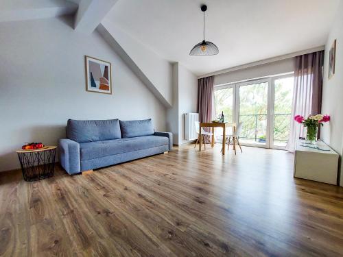 een woonkamer met een blauwe bank en een tafel bij MR HOME APARTMENTS - Limba in Krakau