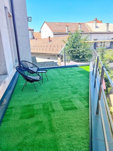 a balcony with a green yard with a chair at The Nest Boutique in Baia Mare