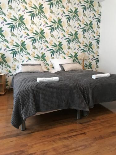 a bedroom with a bed with a tropical wallpaper at Trzy Żagle in Mikołajki